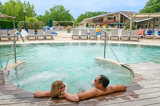 Koppel ontspant in jacuzzi bij zwembad op camping CLICOCHIC Bimbo in BISCARROSSE (40).