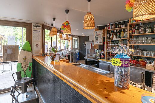 Binnenbar met houten toonbank en drankjes op camping CLICOCHIC Bimbo in BISCARROSSE.