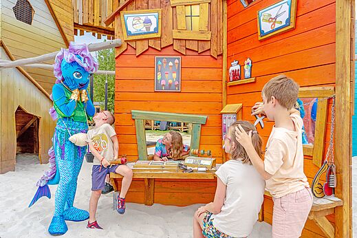 Kinderen en mascotte in speeltuin op camping VAGUES OCEANES Bois Joly in Saint-Jean-de-Monts.