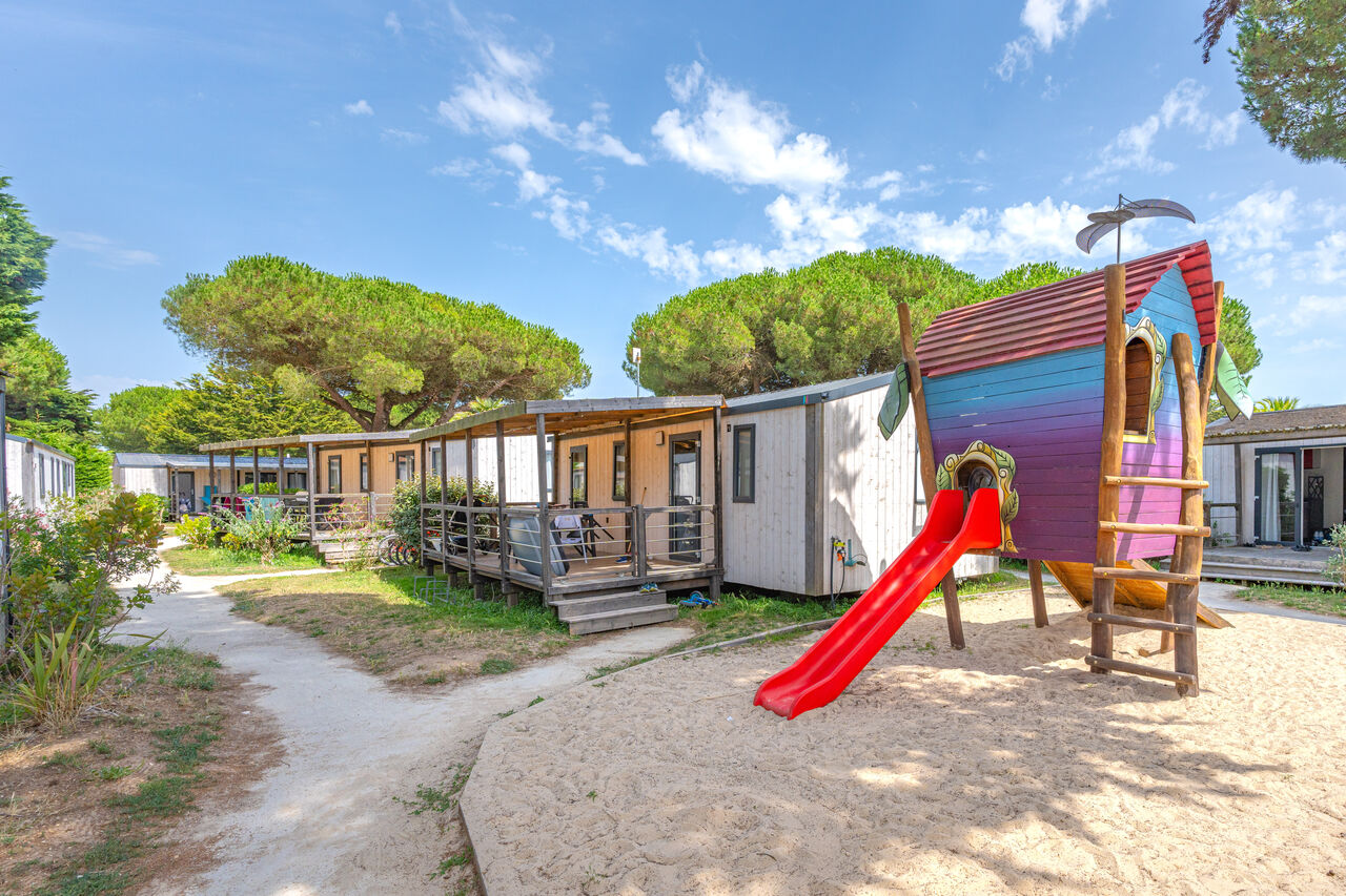 Speeltuin, glijbaan en stacaravans op camping CAPFUN Bonne Etoile in BOIS PLAGE EN RE (17).