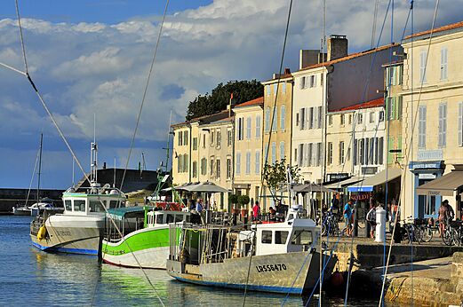 Levendige vissershaven met boten en kleurrijke gevels in La Rochelle.