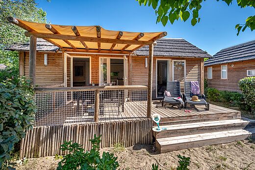Houten stacaravan met terras en stoelen op camping CAPFUN Boucanet.