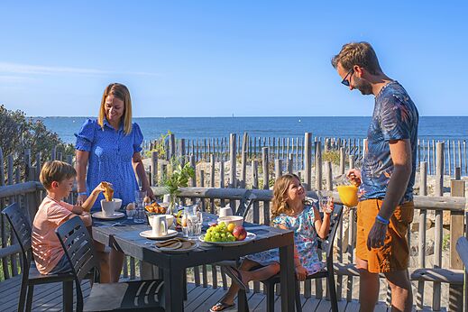 Familieontbijt op terras met zeezicht op camping CAPFUN Boucanet.