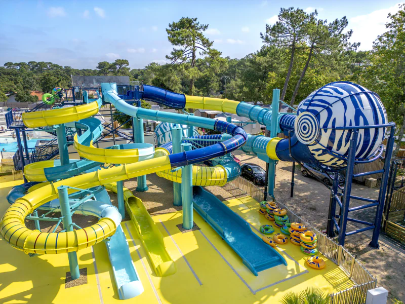 Waterpark met kleurrijke glijbanen en bolvormige structuur op camping VAGUES OCEANES Boudigau in LABENNE OCEAN (40).