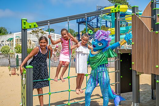 Kinderen en mascotte op speeltoestel bij camping VAGUES OCEANES Boudigau in LABENNE OCEAN (40).