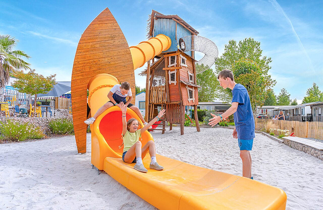 Kinderen op glijbaan en speeltuin op camping CLICOCHIC Brandais in Brem sur Mer.