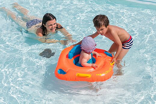 Familiezwembad met baby in zwemband op camping CLICOCHIC Brandais in Brem sur Mer.