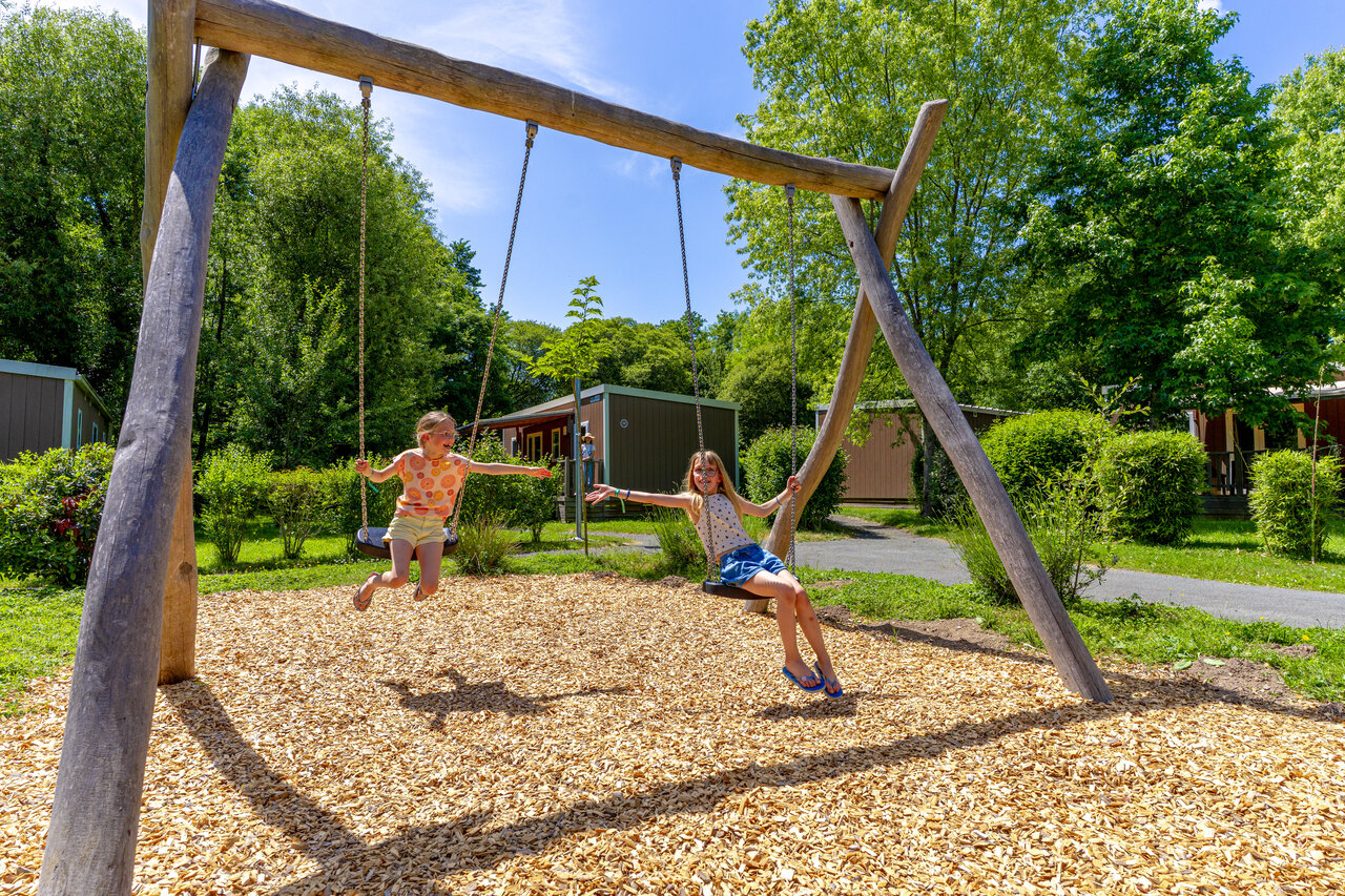 Speeltuin met kinderen op schommels op camping CAPFUN Breteche in Les Epesses (85).