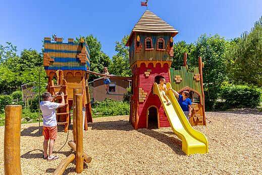 Speeltuin kasteel met glijbaan en kinderen op camping CAPFUN Breteche in Les Epesses (85).