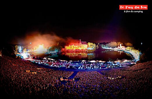 Groots nachtspektakel in Puy du Fou, verlicht kasteel en speciale effecten.