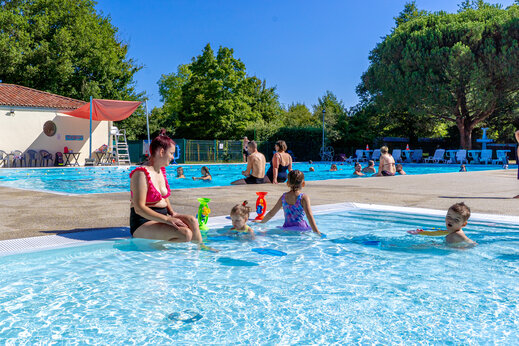 Familie buitenzwembad met spelende kinderen op camping CAPFUN Breteche in Les Epesses (85).