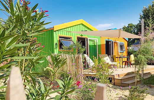 Kleurrijke stacaravan met houten terras en buitenmeubilair op camping CLICOCHIC Cabanes d Oléron in ST GEORGES D'OLERON (17)