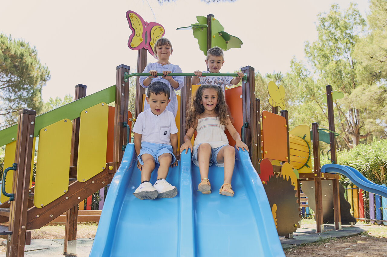 Kinderen op glijbanen speeltuin op CAPFUN Campo dei Fiori in Rosignano Marittimo.