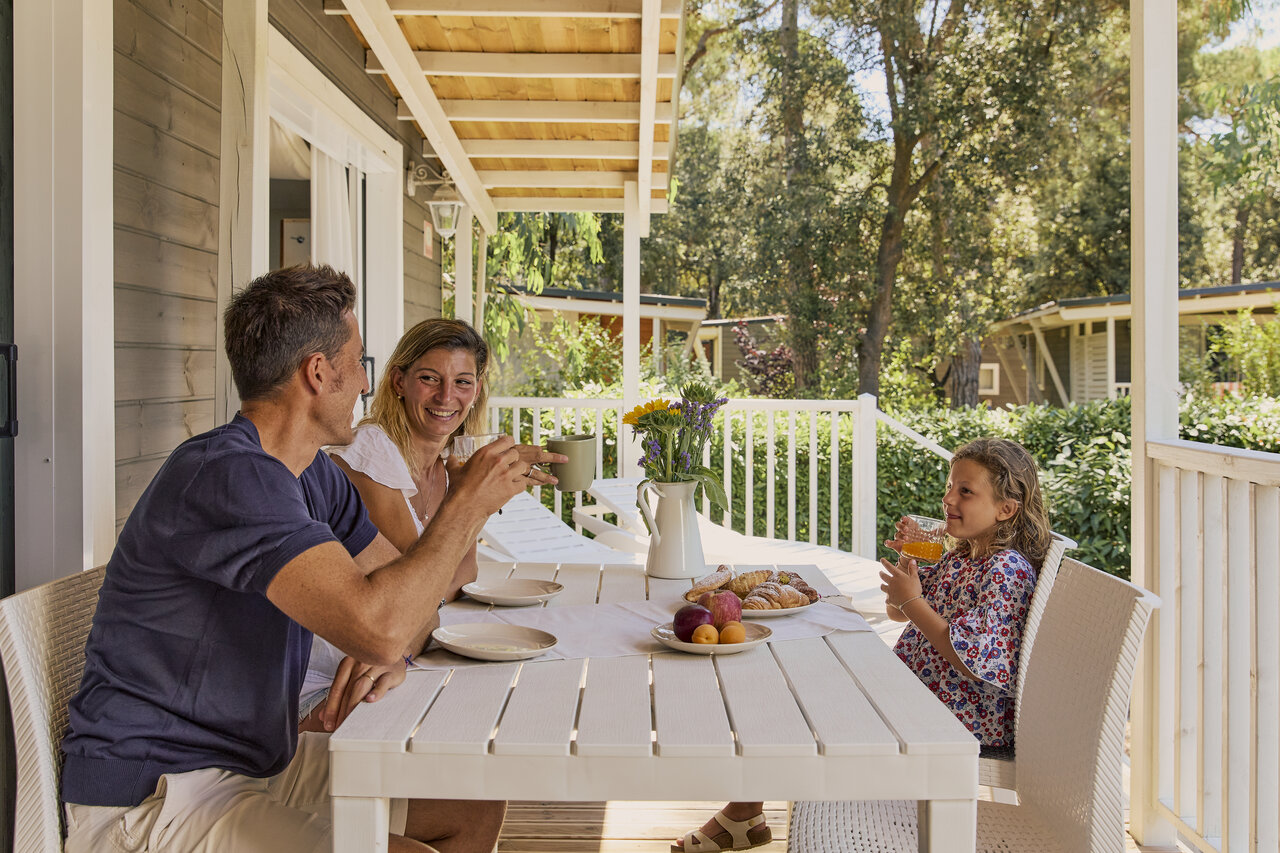 Familie ontbijtend terras stacaravan op CAPFUN Campo dei Fiori in Rosignano Marittimo.