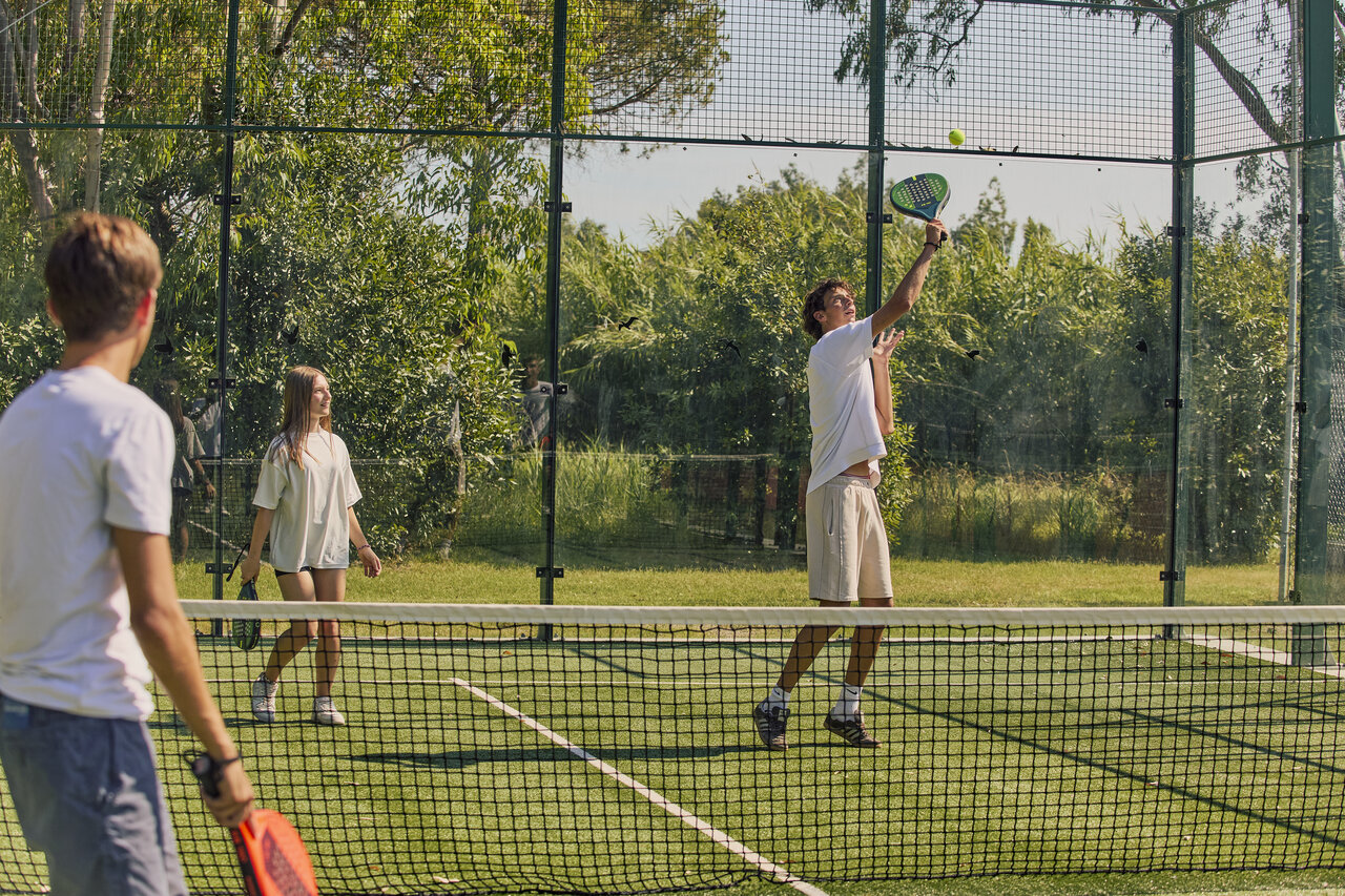 Jongeren padel spelend op de baan van camping CAPFUN Campo dei Fiori in Rosignano Marittimo.