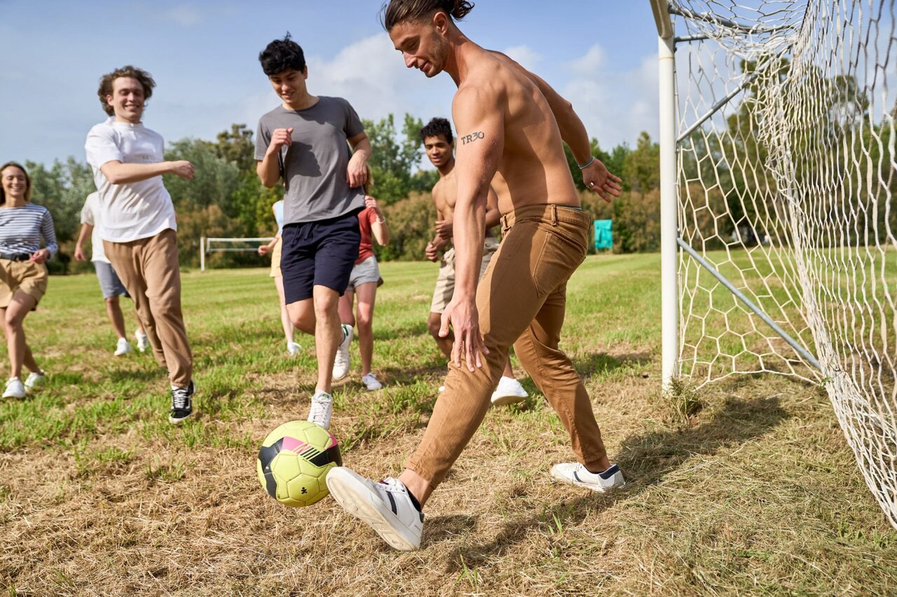 Voetbal tussen jongeren op sportveld op camping CAPFUN Campo dei Fiori.