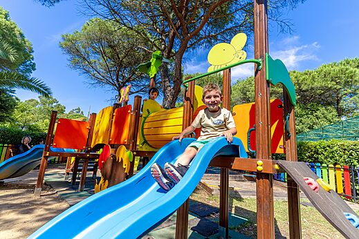 Lachend kind op een kleurrijke glijbaan in de speeltuin op camping CAPFUN Campo dei Fiori in Rosignano Marittimo (57).