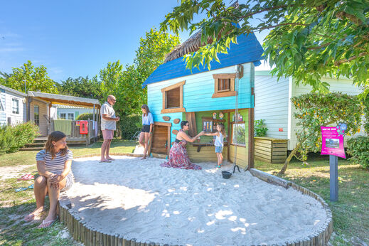 Speeltuin met speelhuisje en zandbak voor kinderen op camping CLICOCHIC Camp du Soleil in Ars-en-Ré (17).