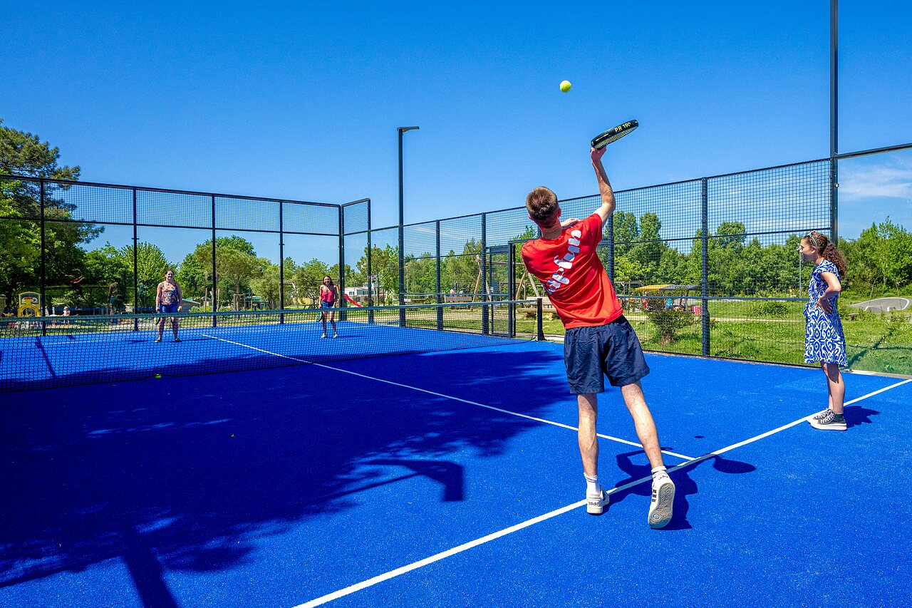 Blauwe padelbaan met spelers op camping CAPFUN Cenic in PENESTIN (56).