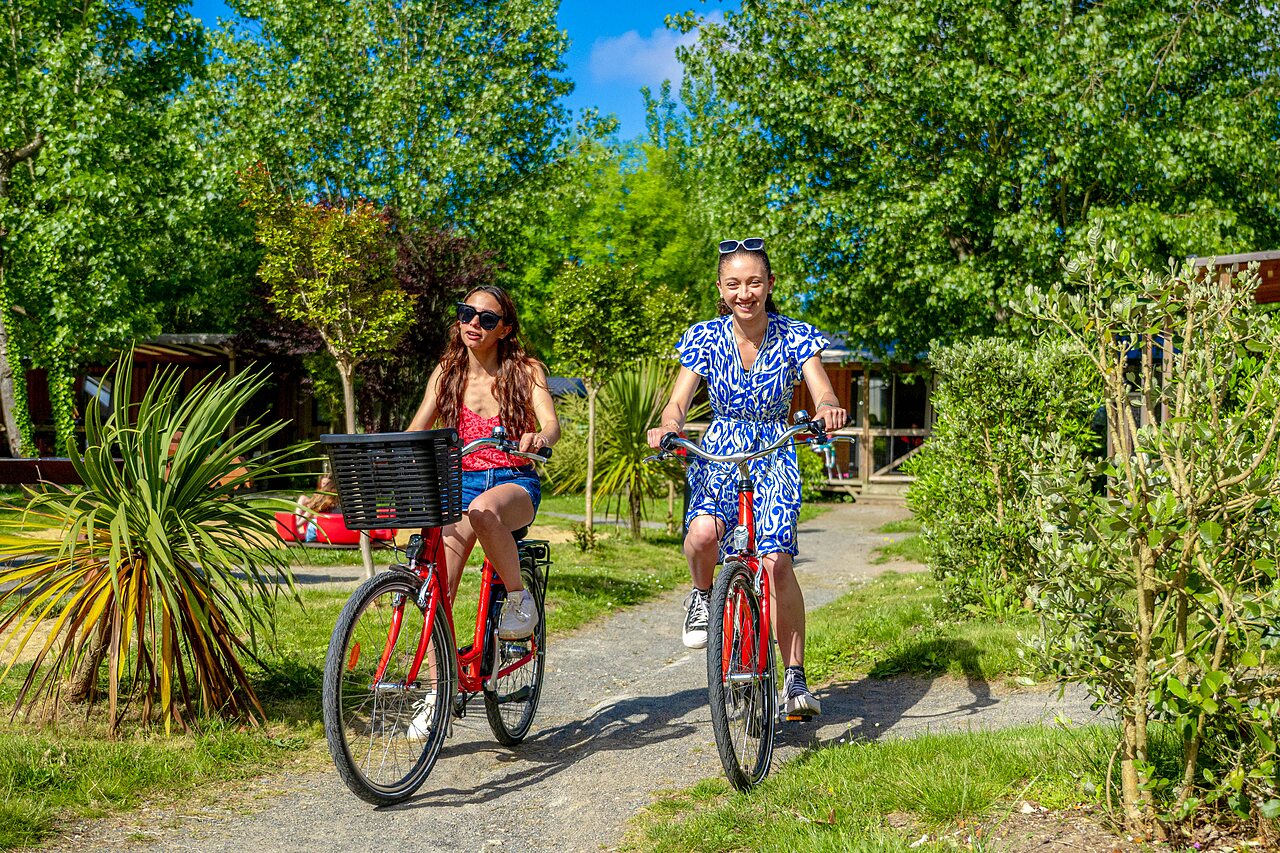 Vrouwen fietsen op groen pad op camping CAPFUN Cenic in PENESTIN (56).