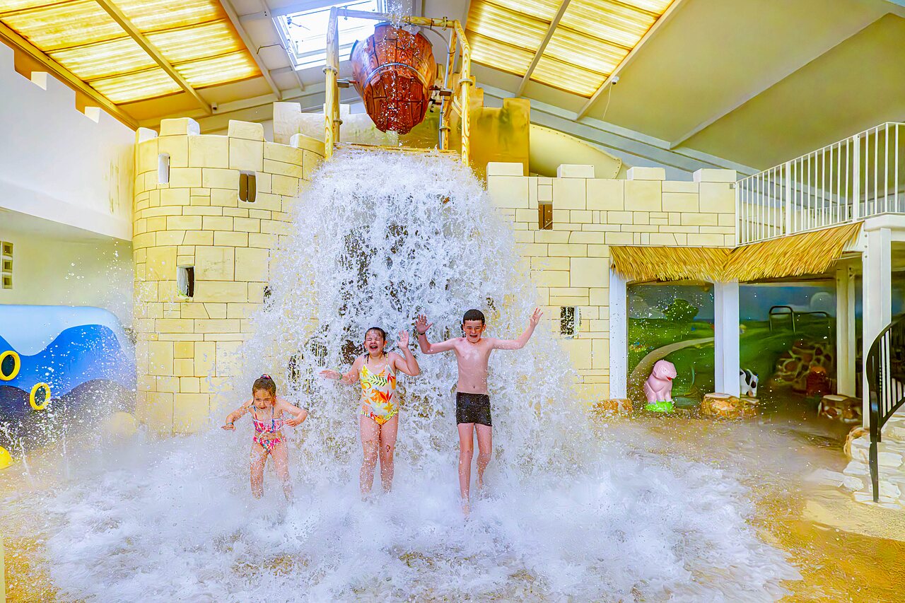 Kinderen onder de gigantische wateremmer in het zwembad van camping CAPFUN Cenic in PENESTIN (56).
