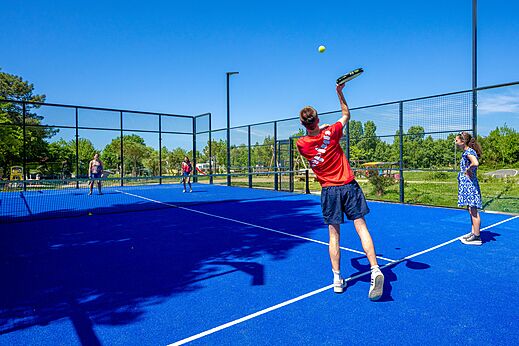Blauwe padelbaan met spelers op camping CAPFUN Cenic in PENESTIN (56).