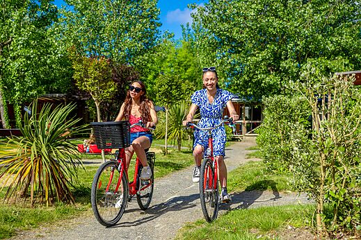 Twee vrouwen fietsen op groen pad op camping CAPFUN Cenic in PENESTIN (56).