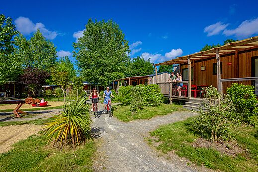 Stacaravans met terrassen en fietsende mensen op camping CAPFUN Cenic in PENESTIN (56).