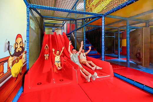 Binnenspeeltuin met glijbanen en kinderen op camping CAPFUN Cenic in PENESTIN (56).