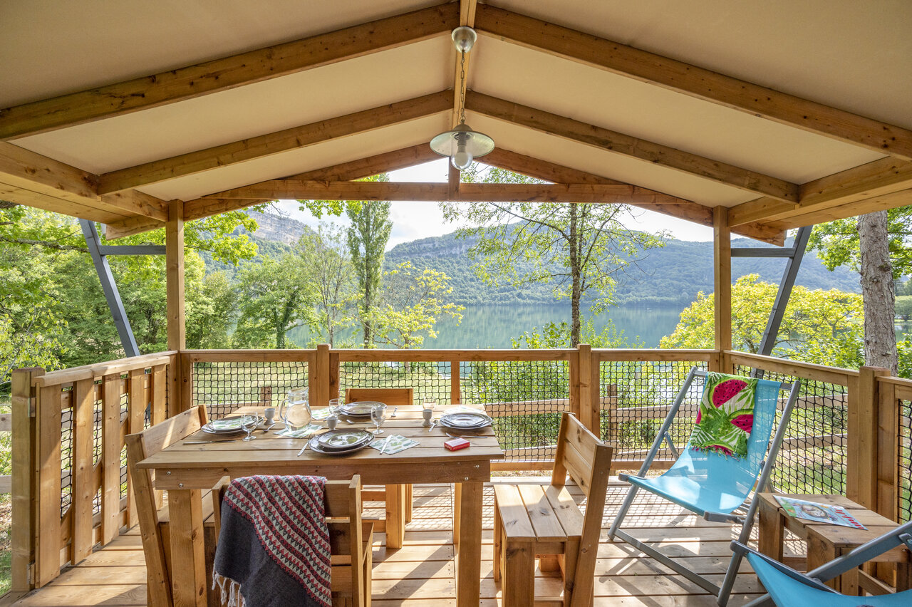 Overdekt terras accommodatie met tafel en meerzicht bij CLICOCHIC Chancia (01).