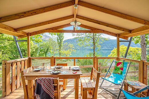 Terras van stacaravan, uitzicht meer, op camping CLICOCHIC Chancia (01).