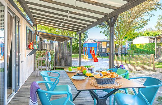 Terras van stacaravan met ontbijt en speeltuin op camping VAGUES OCEANES Domaine les Charmilles in Saint-Laurent-de-la-Prée (17).