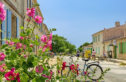 Bloemrijke straat van een typisch dorp met fietsen, te bezoeken nabij de camping.