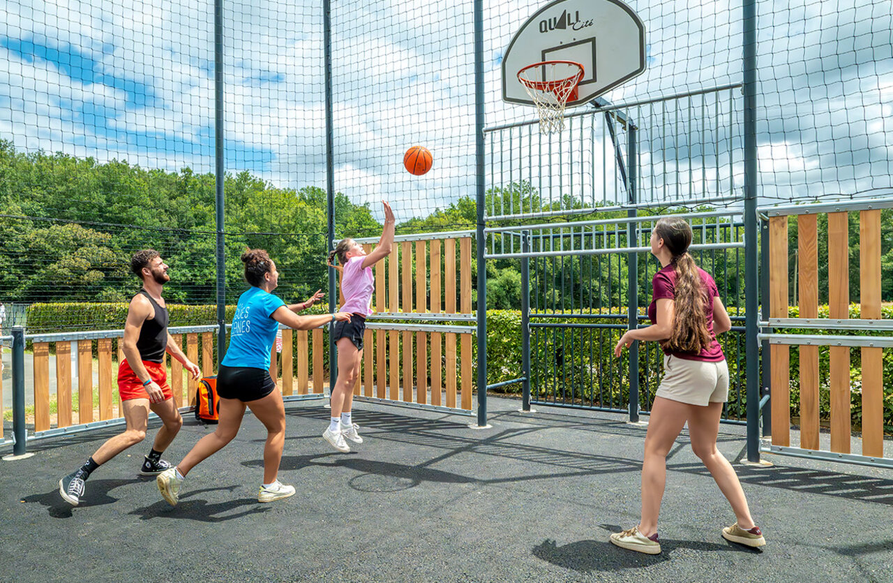 Multisport basketbalveld met jongeren spelend op camping VAGUES OCEANES Chataigneraie in Prats-de-Carlux.