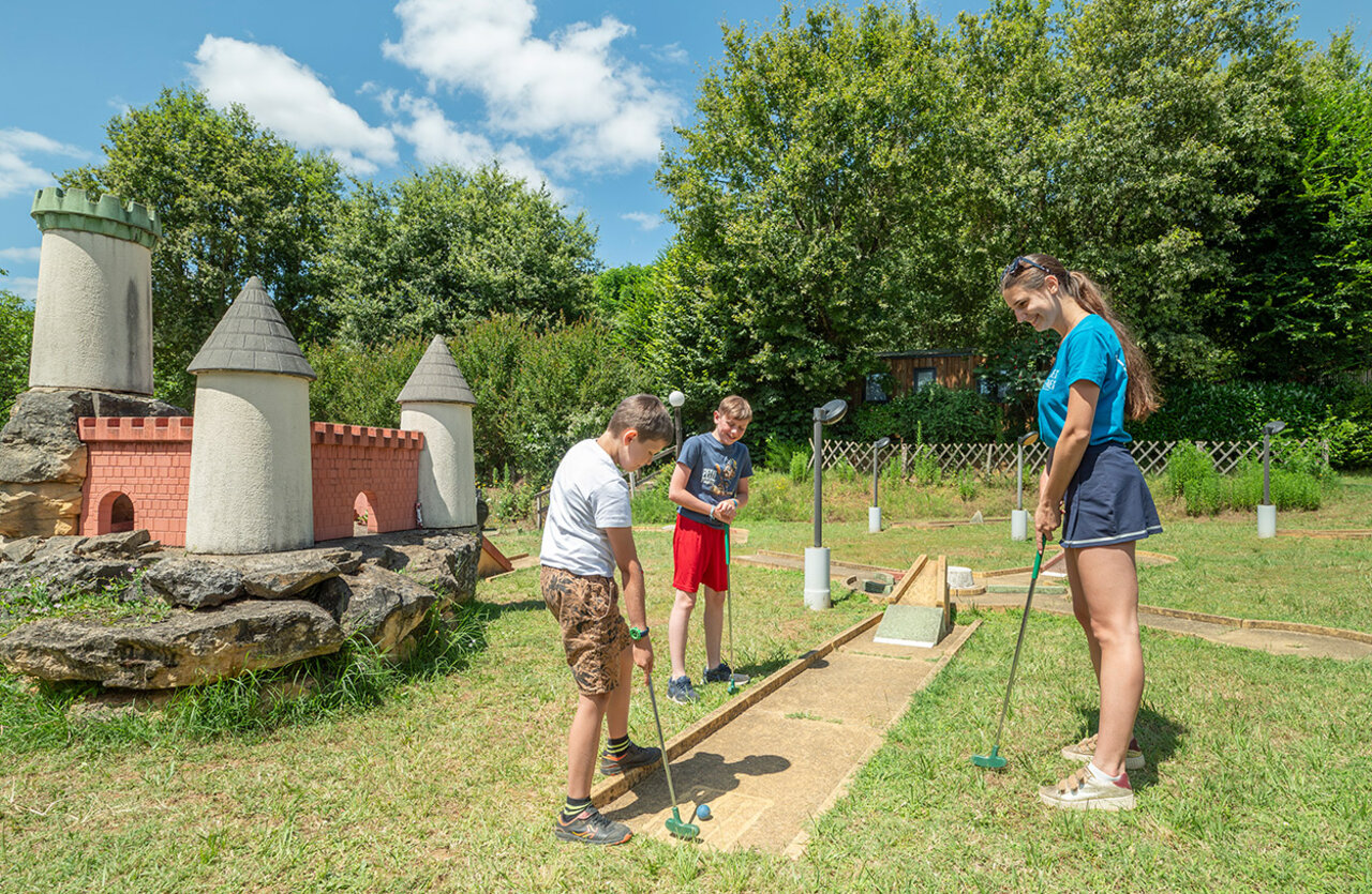 Minigolfbaan met miniatuurkasteel, kinderen en volwassene op camping VAGUES OCEANES Chataigneraie.