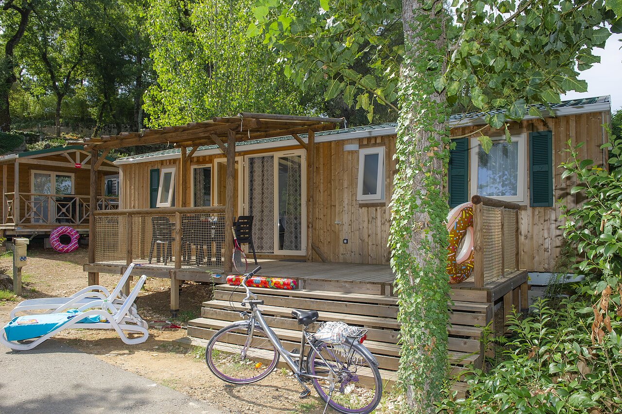 Houten stacaravan met terras en fiets op camping CLICOCHIC Ch�teau de Boisson in All�gre-les-Fumades (30).
