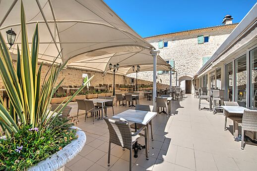 Schaduwrijk buitenterras restaurant op camping CLICOCHIC Château de Boisson.