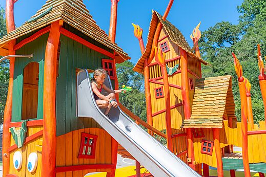 Kind op glijbaan kleurrijke speeltuin op camping CLICOCHIC Château de Boisson in Allègre-les-Fumades (30).