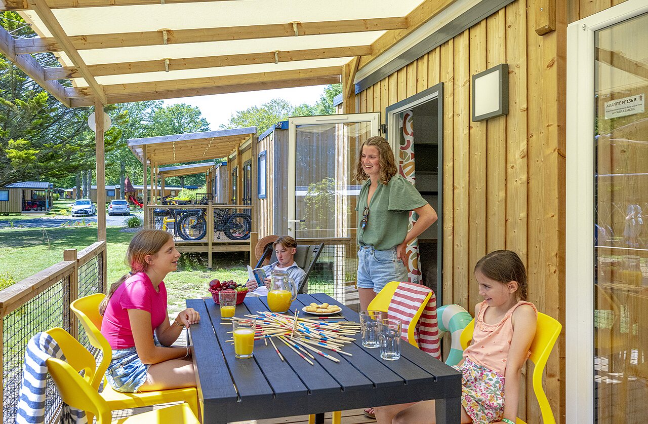 Familie genietend van overdekt terras stacaravan met spel op camping CAPFUN Ch�teau de Galin�e in SAINT CAST LE GUILDO (22).