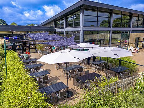 Buitenterras van het restaurant met tafels en parasols op camping CAPFUN Ch�teau de Galin�e.