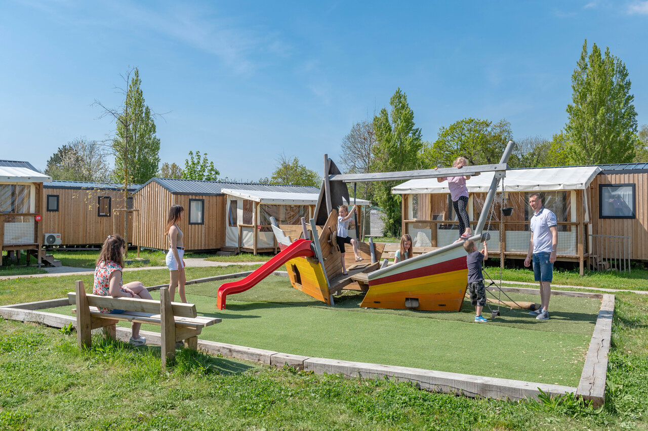 Speeltuin boot met glijbaan en kinderen, stacaravans op camping CAPFUN Chateau d'Arvid in Villerville (14).