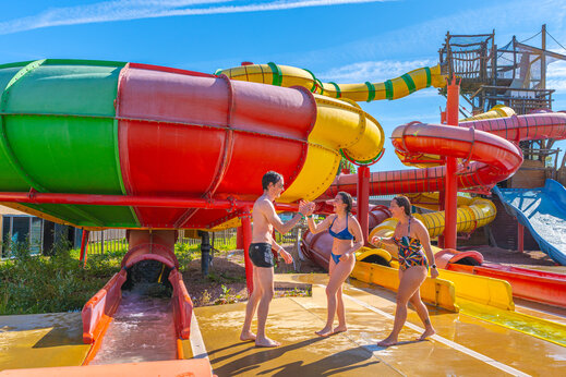 Kleurrijke waterglijbanen en blije mensen op camping CAPFUN Chateau d'Arvid in Villerville (14).