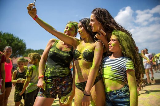 Animatie kleurenfeest, lachende groep maakt een selfie op camping CAPFUN Chateau d'Arvid.