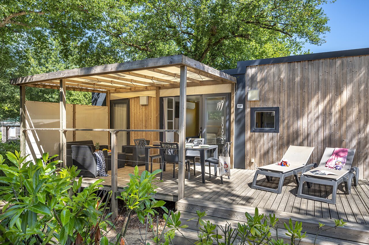 Moderne stacaravan met ingericht terras en ligstoelen op camping CAPFUN La Ch�naie in PORNIC (44).