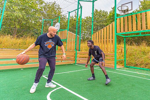 Basketbalveld met twee mannen spelend op camping CAPFUN La Chênaie in PORNIC (44).