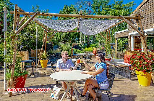Schaduwrijk restaurantterras met stel op camping CAPFUN La Chênaie in PORNIC (44).