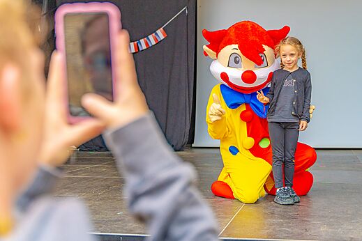 Kleurrijke mascotte en kind poseren voor foto camping CAPFUN La Chênaie PORNIC.