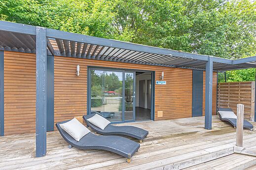 Moderne stacaravan met houten terras en stoelen op camping CAPFUN La Chênaie in PORNIC (44).