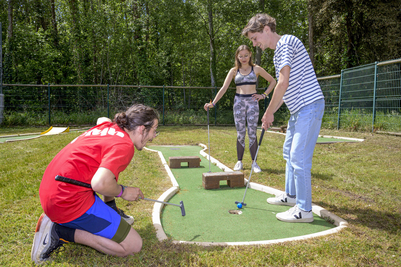 Jongeren vermaken zich met minigolf op camping CAPFUN Ch�nes in Medis/Royan.