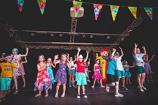 Kinderen en mascotte dansen op podium, animatie op camping CAPFUN Chênes in Medis/Royan.
